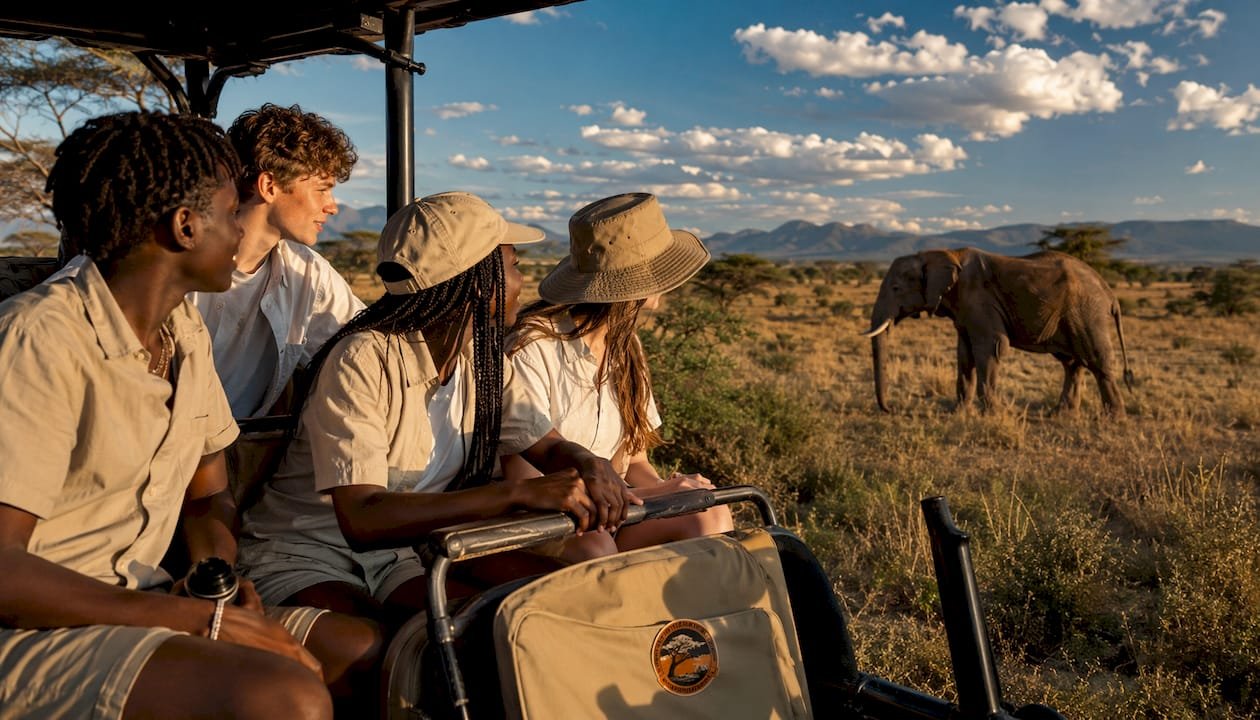Un gruppo di ragazzi osserva da vicino un leone durante un emozionante safari in Kenya.