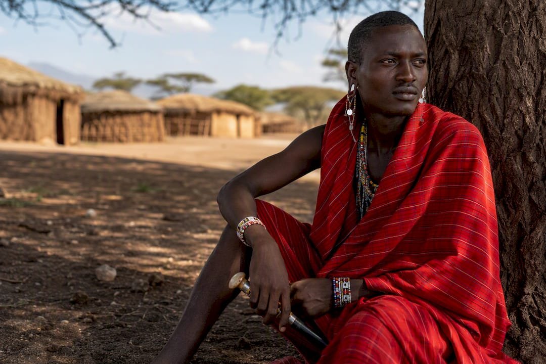 Guerriero Maasai in piedi vicino al villaggio