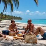 L’alba a Diani Beach: le prime luci del sole che filtrano tra le palme, mentre il mare si risveglia lentamente.
