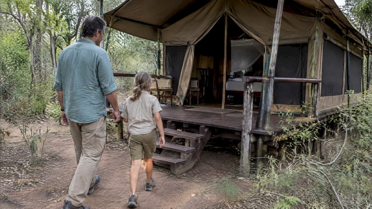 Famiglia che guarda una tenda safari con il bambino, Bambini nei lodge safari